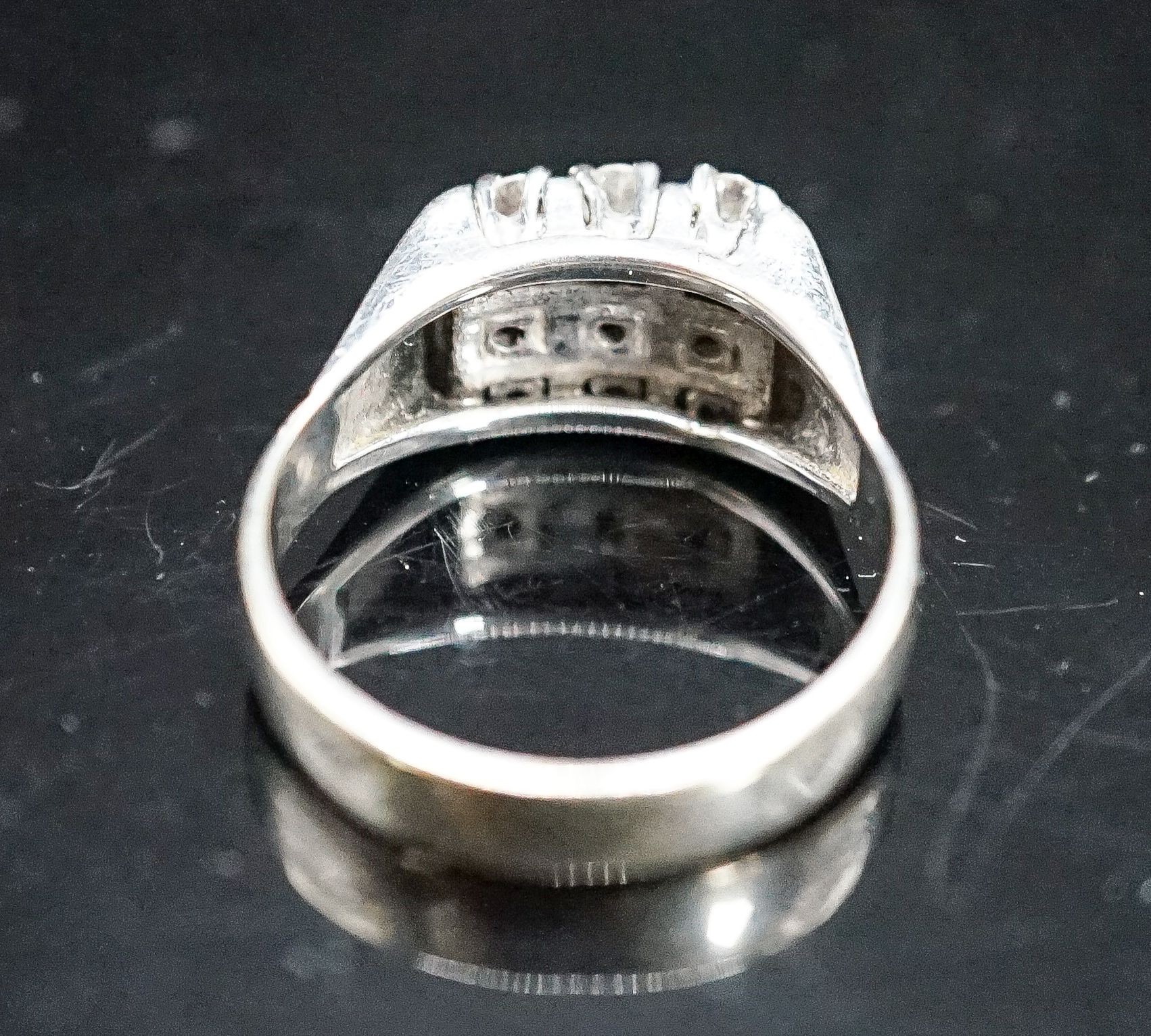 A 750 white metal and nine stone diamond set tablet ring, size S/T, gross 7.6 grams.